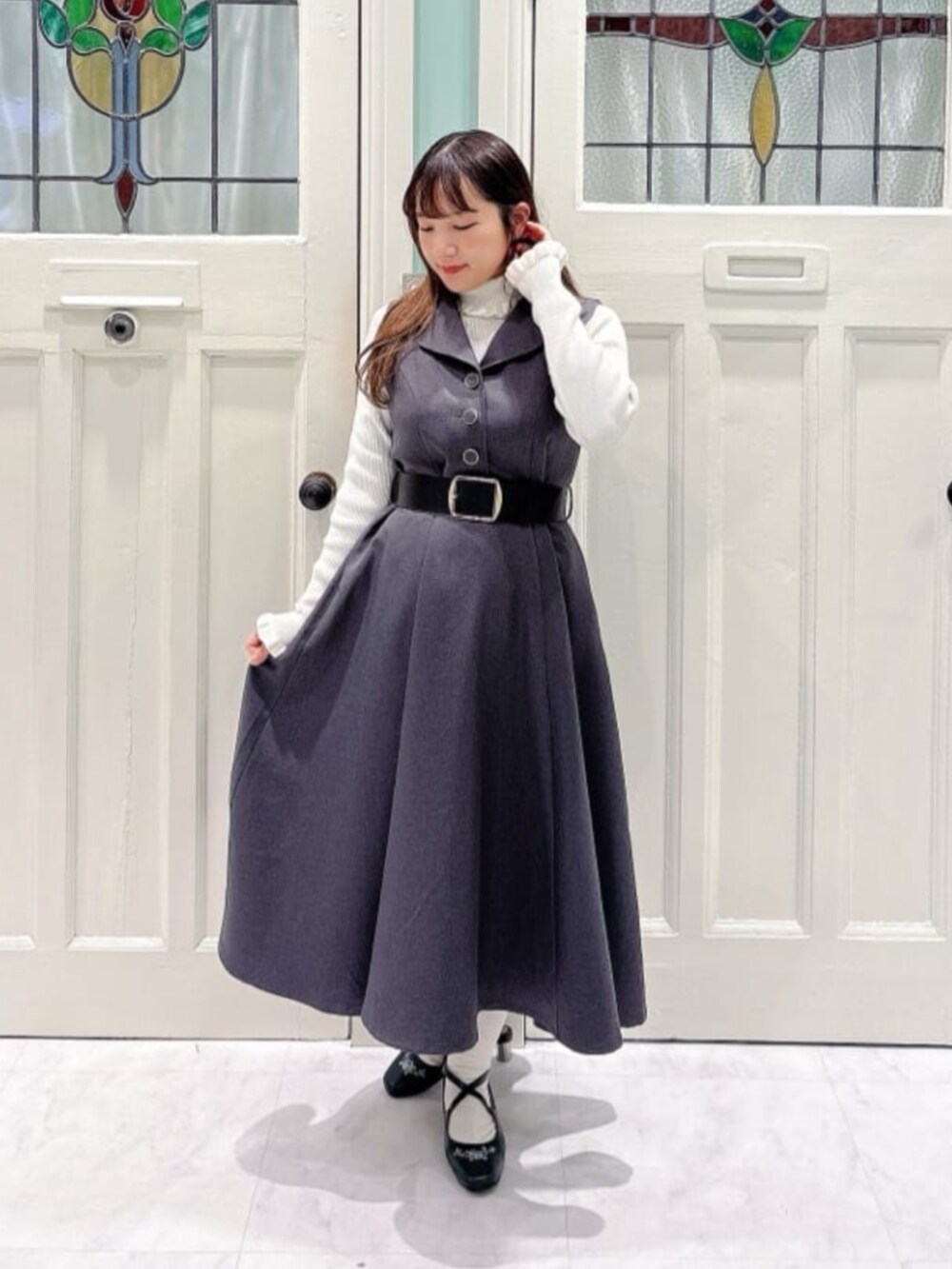 ブラック系のトートバッグ、ブルー系のパンプス、ホワイト系のニット/セーターを着用したレディースの秋コーディネートの3枚目の写真