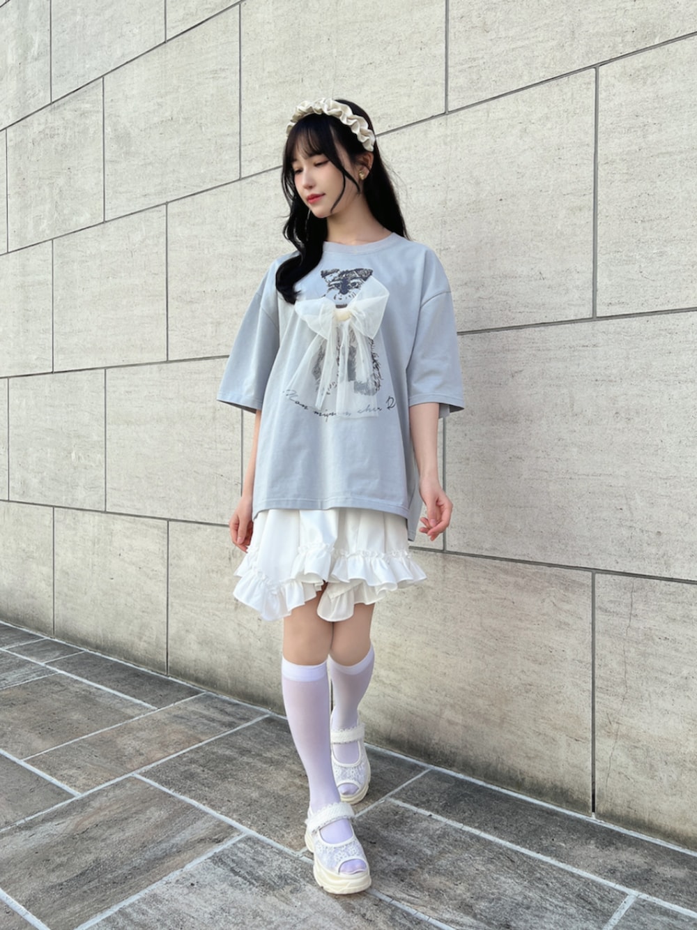 ホワイト系のスカート、ホワイト系のサンダル、グレー系のTシャツ/カットソーを着用したレディースの夏コーディネートの2枚目の写真