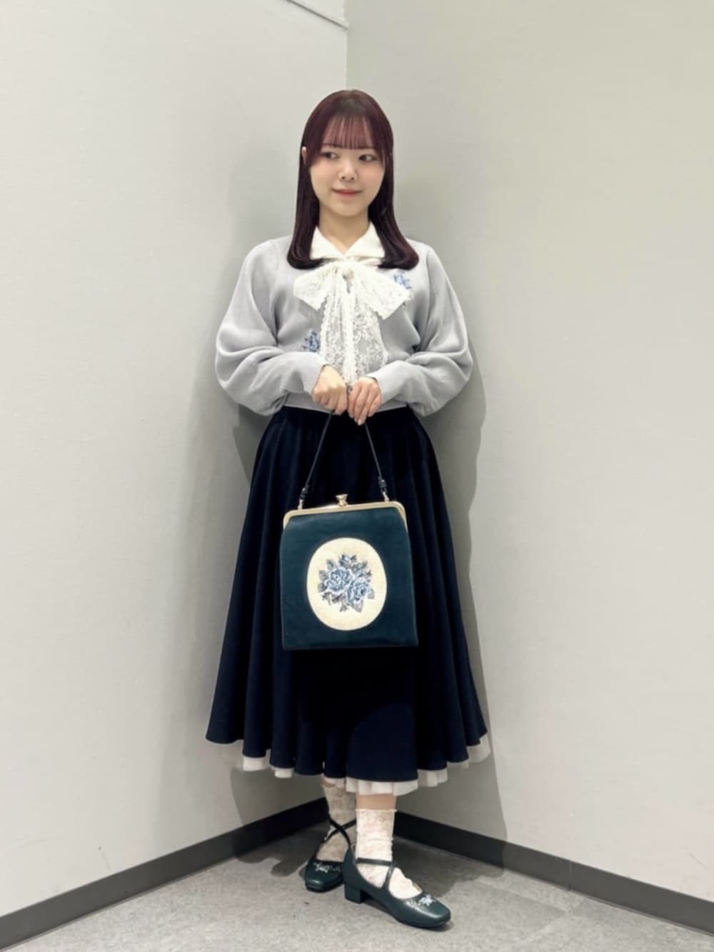 ブルー系のパンプス、ブルー系のハンドバッグ、ホワイト系のシャツ/ブラウスを着用したレディースの冬コーディネートの2枚目の写真