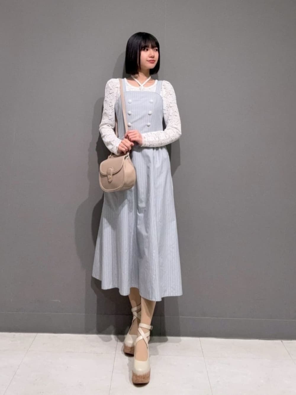 ホワイト系のパンプス、ホワイト系のTシャツ/カットソー、ブルー系のワンピースを着用したレディースの春コーディネートの4枚目の写真