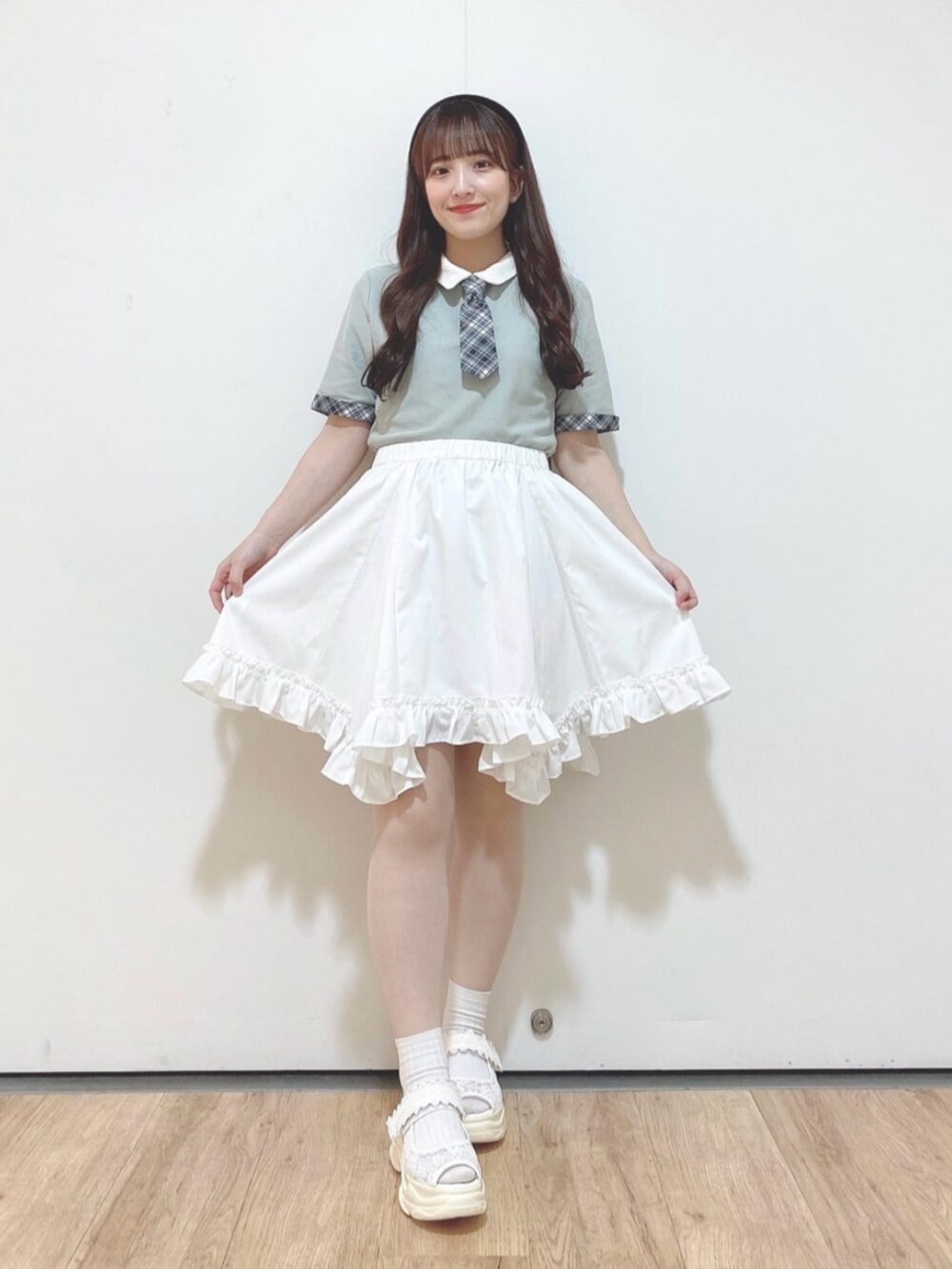 ホワイト系のハンドバッグ、ホワイト系のスカート、ホワイト系のサンダルを着用したレディースの春コーディネートの3枚目の写真