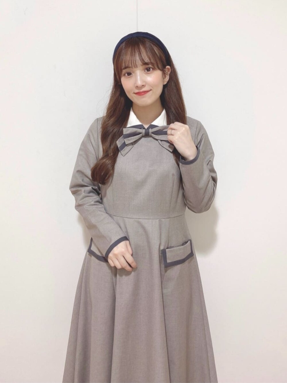 ブルー系のショルダーバッグ、ブラック系のバレエシューズ、ベージュ系のワンピースを着用したレディースの秋コーディネートの2枚目の写真