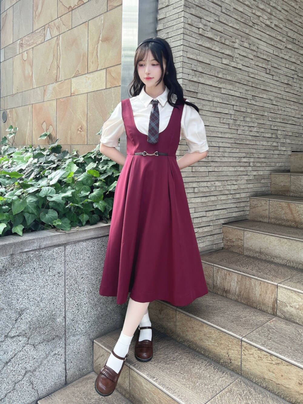 ブラウン系のローファー、レッド系のジャンパースカート、ホワイト系のTシャツ/カットソーを着用したレディースの夏コーディネートの2枚目の写真