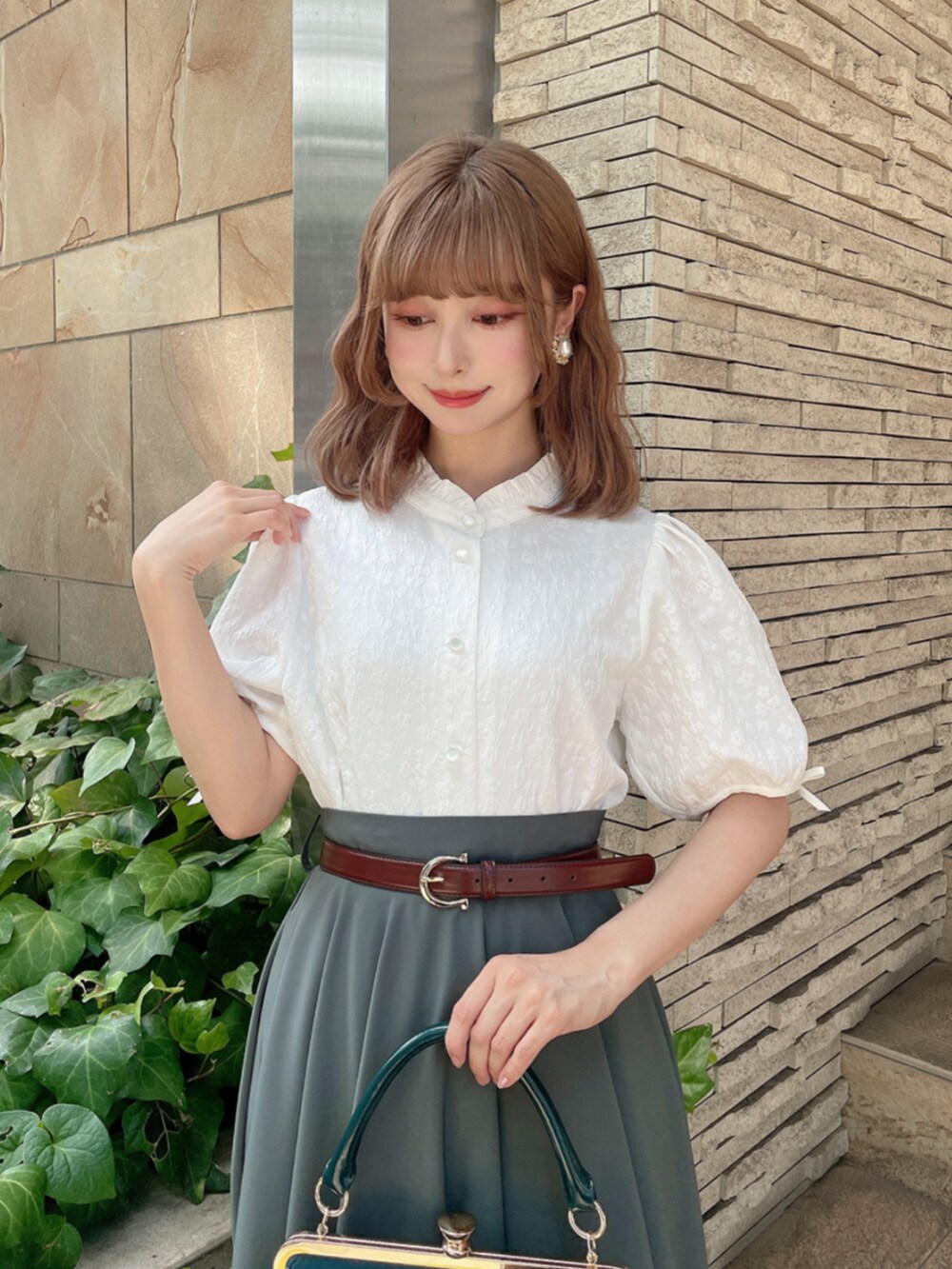 ホワイト系のシャツ/ブラウス、グリーン系のスカート、ブルー系のハンドバッグを着用したレディースの秋コーディネートの2枚目の写真