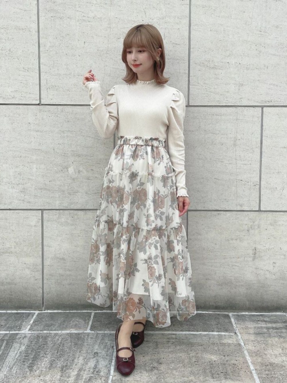レッド系のパンプス、オレンジ系のスカート、ホワイト系のニット/セーターを着用したレディースの秋コーディネートの2枚目の写真