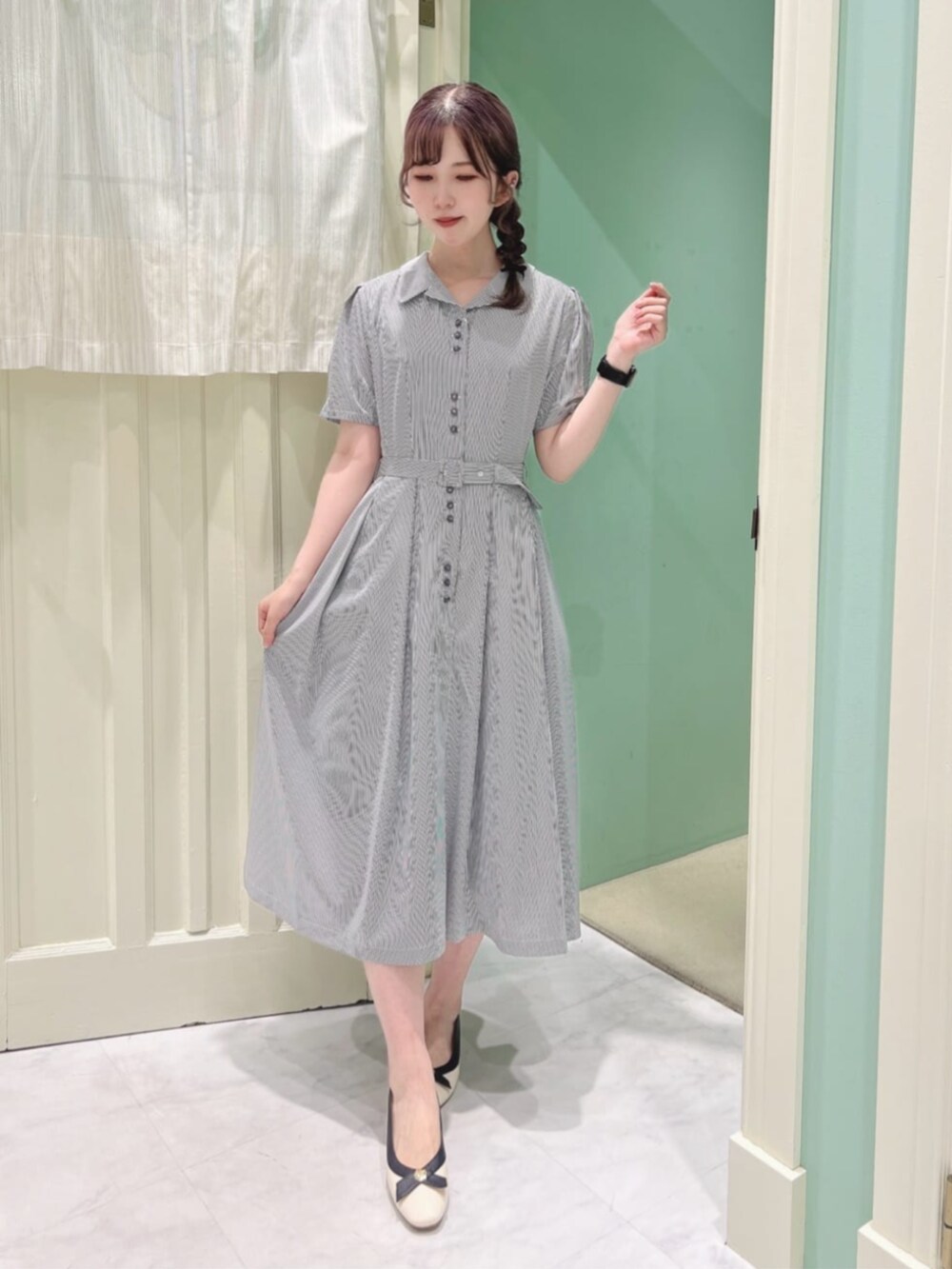 ホワイト系のパンプス、ホワイト系のシャツワンピース、ブルー系のカーディガン/ボレロを着用したレディースの夏コーディネートの2枚目の写真