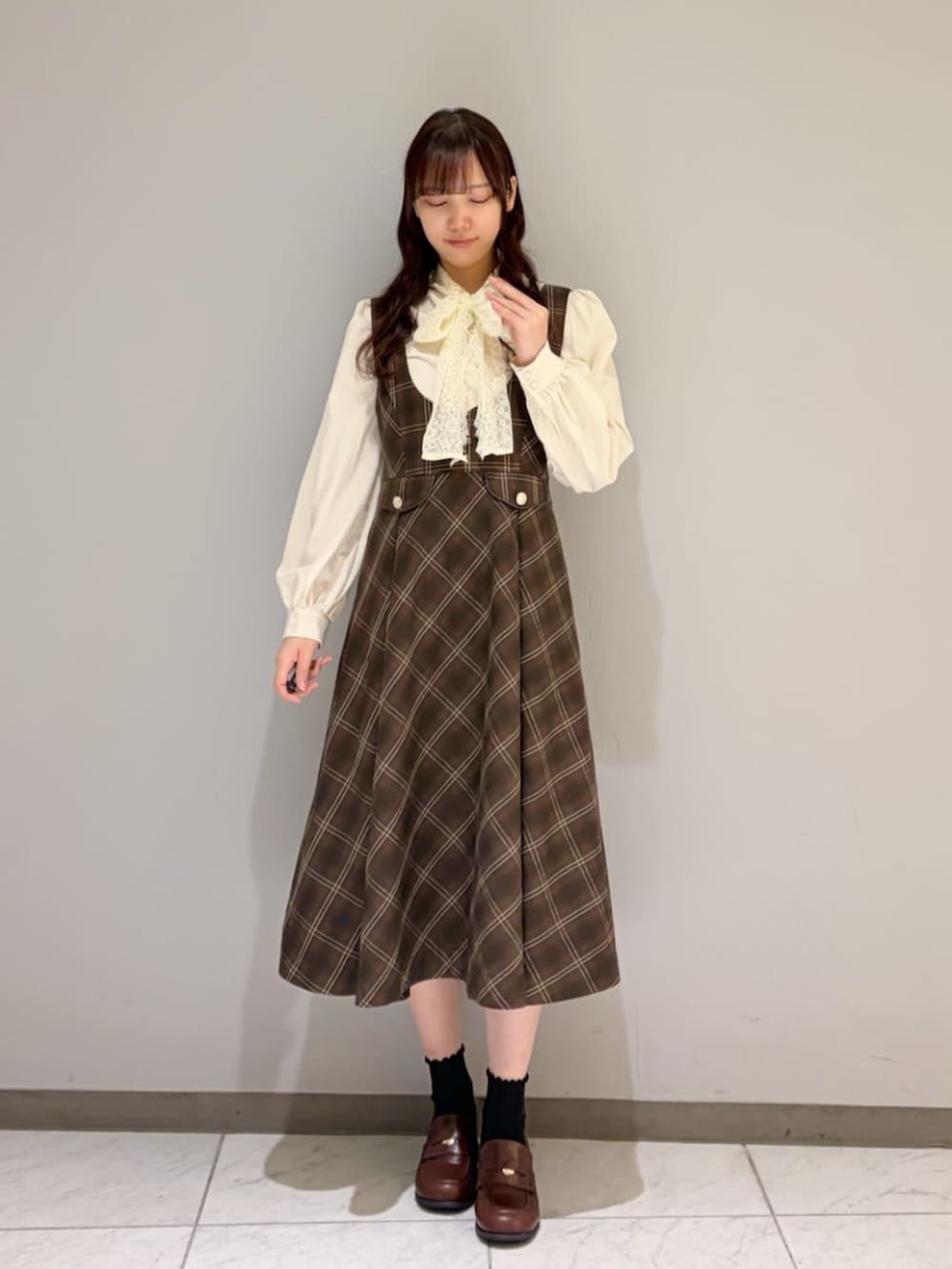 ブラウン系のローファー、ホワイト系のシャツ/ブラウス、ブラウン系のピーコートを着用したレディースの冬コーディネートの3枚目の写真