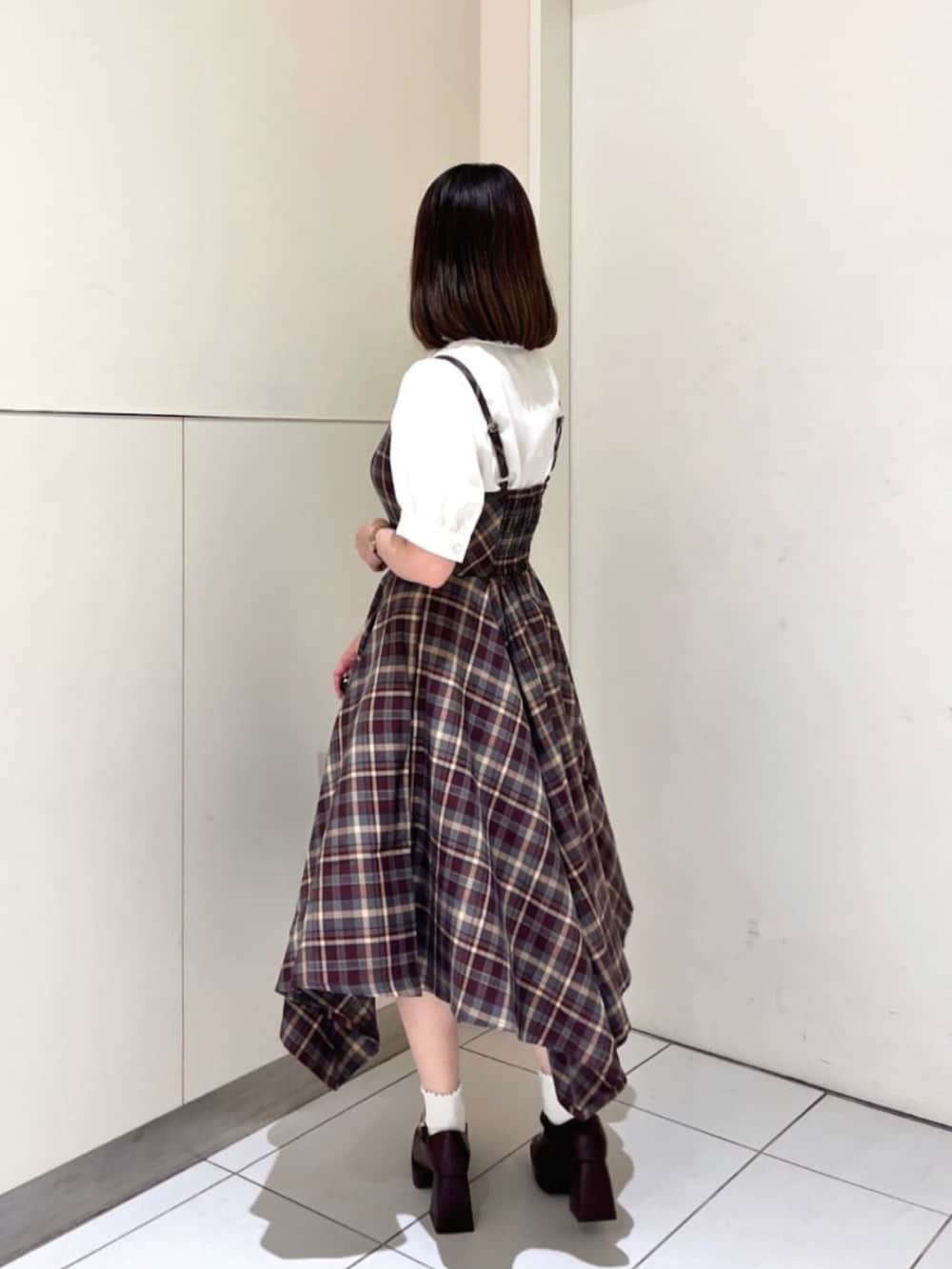 ブラウン系のパンプス、ブラウン系のショルダーバッグ、ホワイト系のシャツ/ブラウスを着用したレディースの夏コーディネートの2枚目の写真