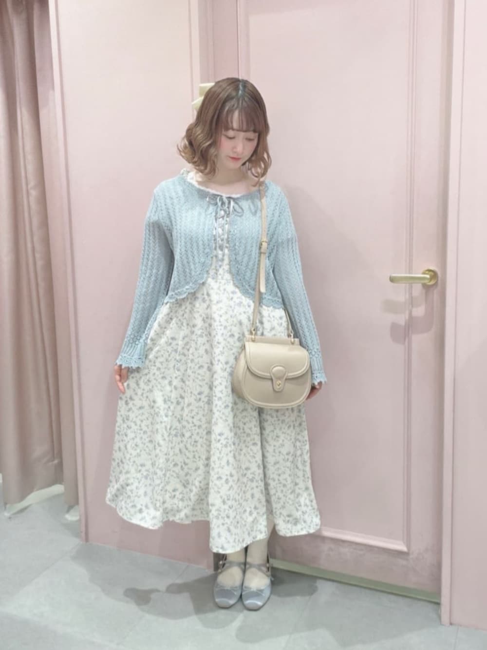 ピンク系のショルダーバッグ、グレー系のパンプス、ホワイト系のワンピースを着用したレディースの春コーディネートの2枚目の写真