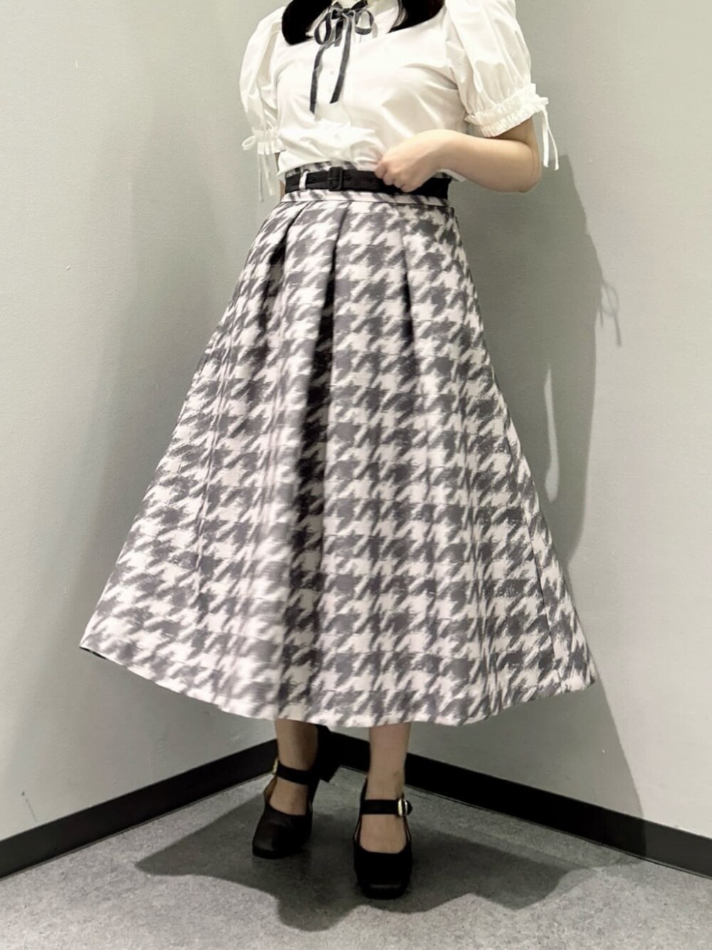 グレー系のスカート、ピンク系のセットアップ、ホワイト系のシャツ/ブラウスを着用したレディースの秋コーディネートの9枚目の写真