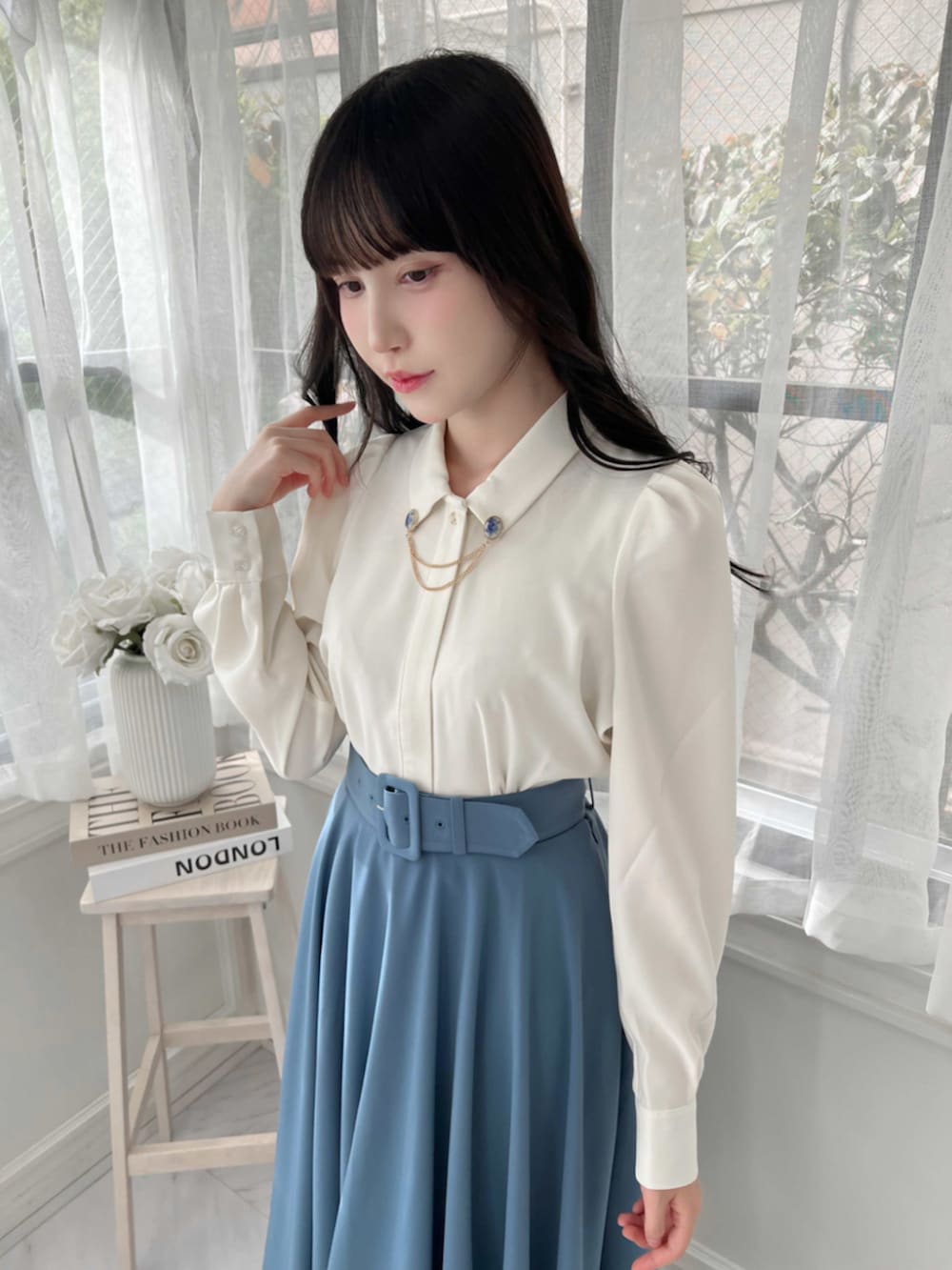 ブルー系のスカート、ホワイト系のシャツ/ブラウス、ブルー系のパンプスを着用したレディースの秋コーディネートの3枚目の写真