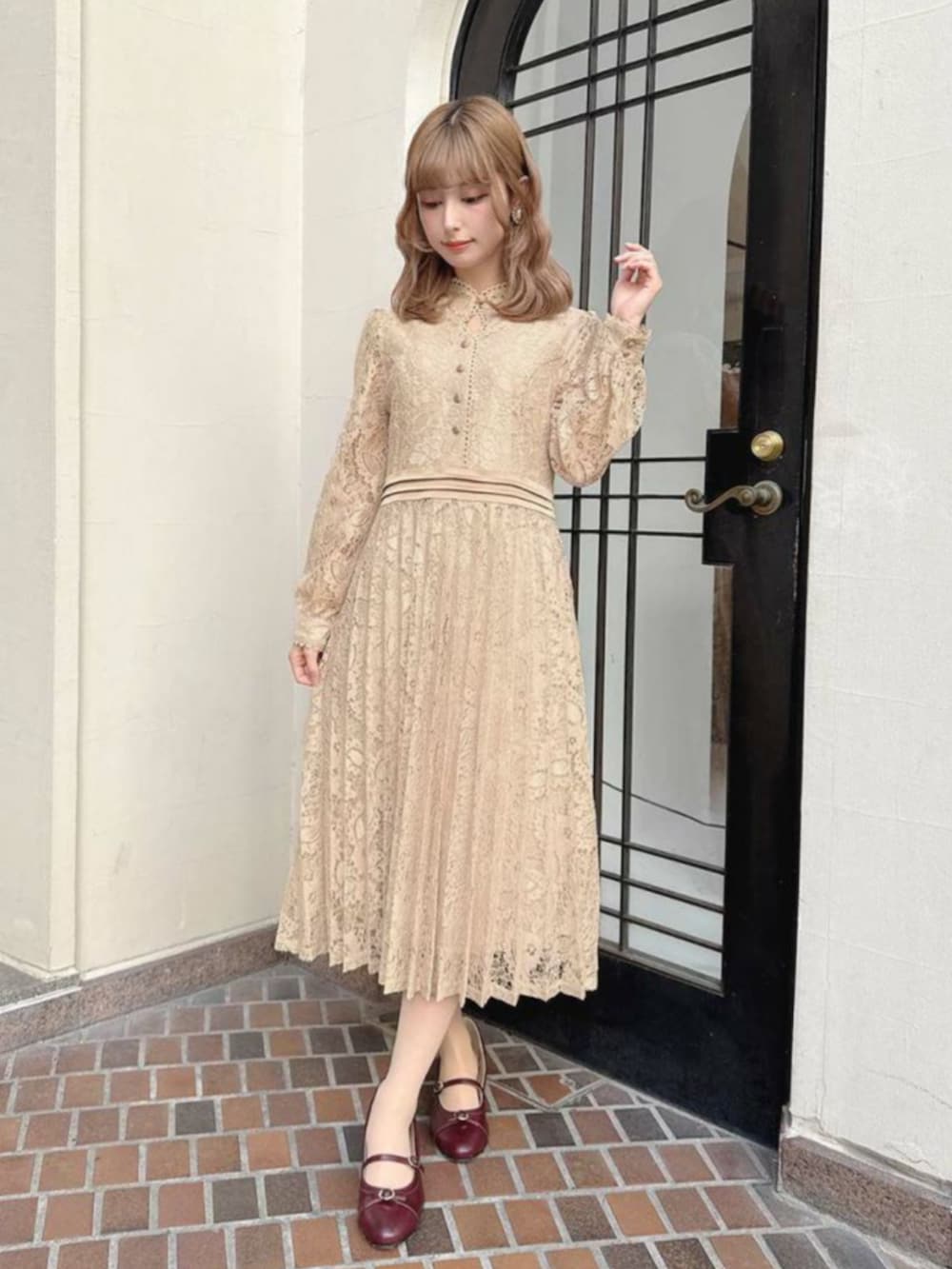 レッド系のパンプス、ピンク系のドレスを着用したレディースの冬コーディネートの2枚目の写真