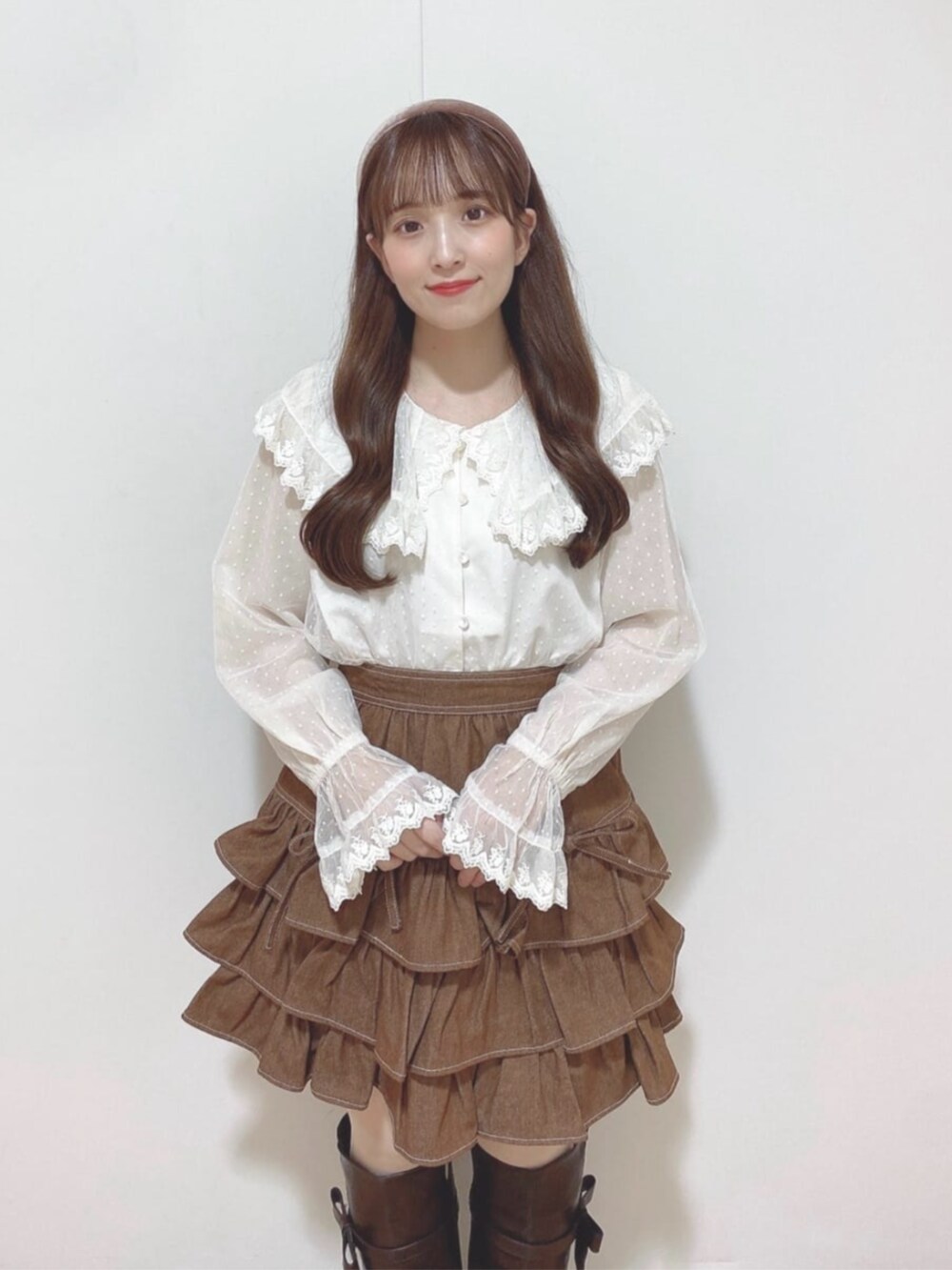 ホワイト系のシャツ/ブラウス、ブラウン系のスカート、ブラウン系のブーツを着用したレディースの秋コーディネートの3枚目の写真