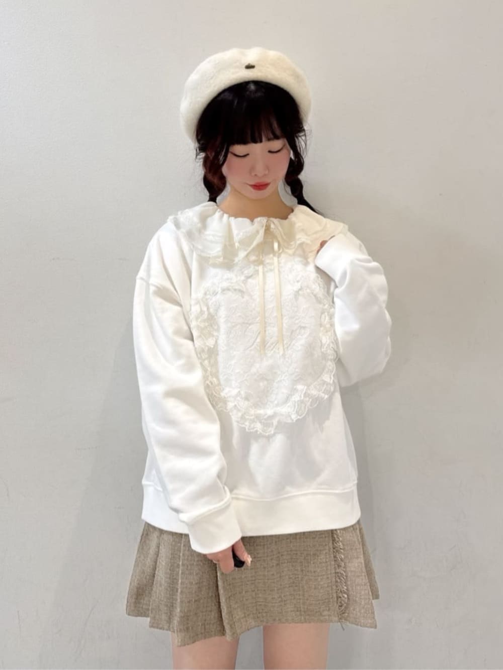 ホワイト系のスウェット、ピンク系のショルダーバッグ、ベージュ系のスカートを着用したレディースの冬コーディネートの2枚目の写真