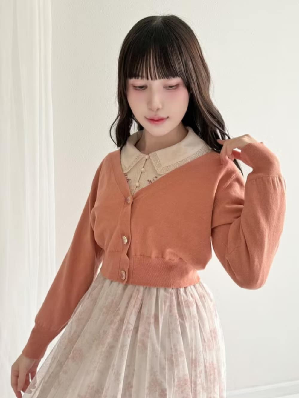 ブラウン系のローファー、ピンク系のカーディガン/ボレロ、オレンジ系のスカートを着用したレディースの春コーディネートの2枚目の写真