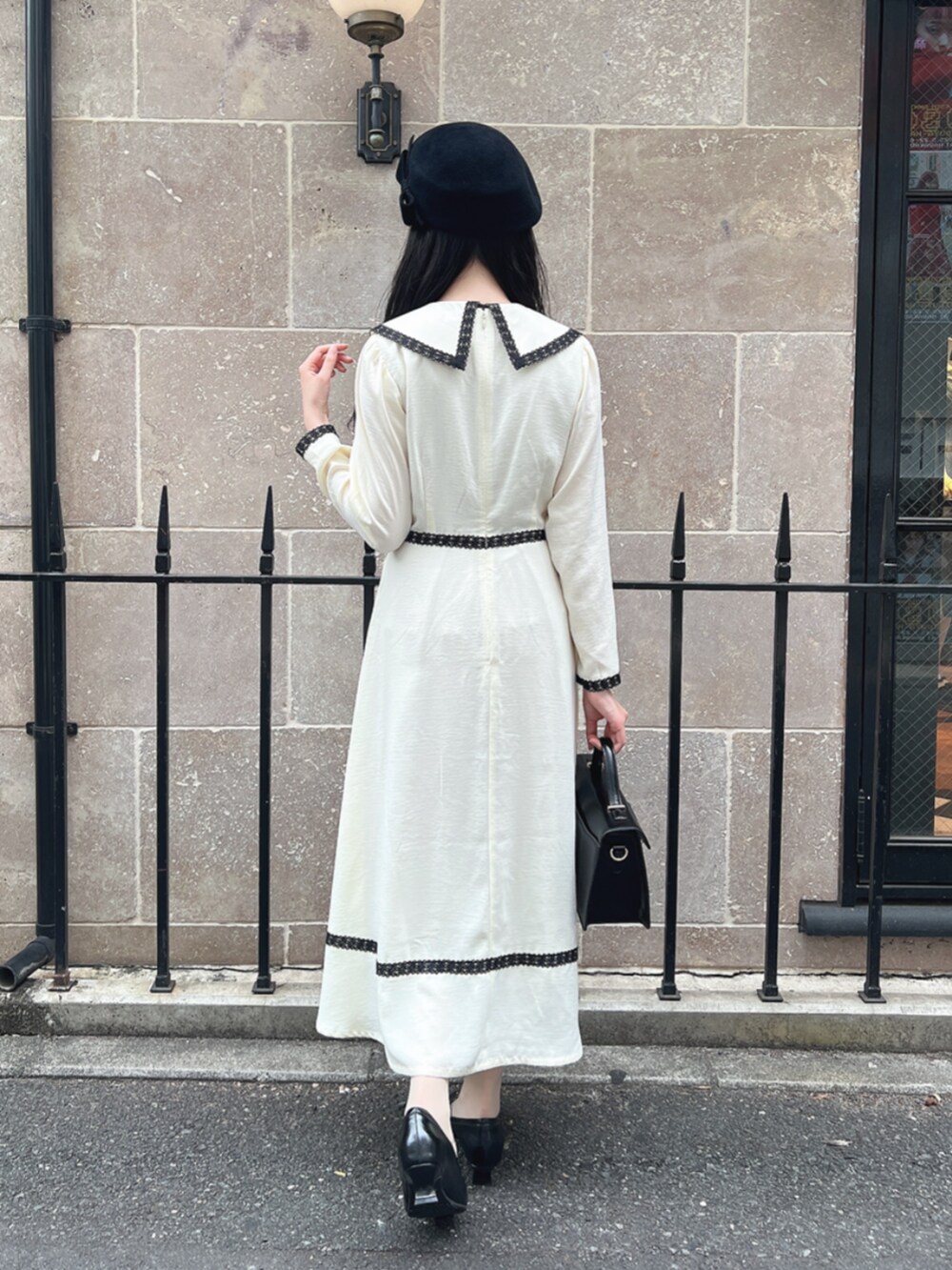 ベージュ系のワンピース、ブラック系のパンプスを着用したレディースの夏コーディネートの3枚目の写真