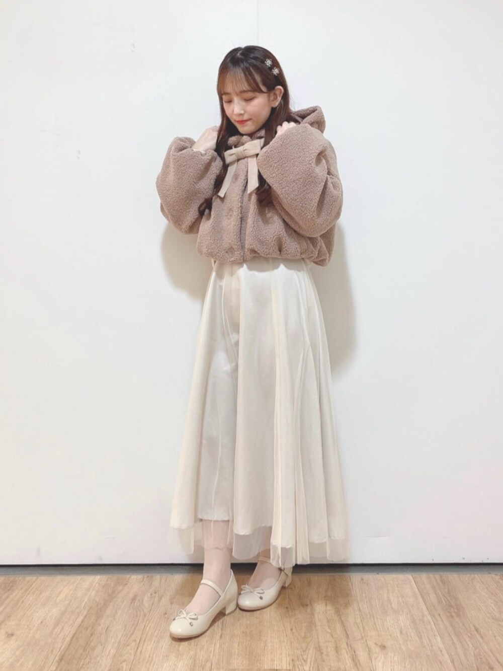 ホワイト系のスカート、ピンク系のその他アウター、ベージュ系のパンプスを着用したレディースの冬コーディネートの2枚目の写真