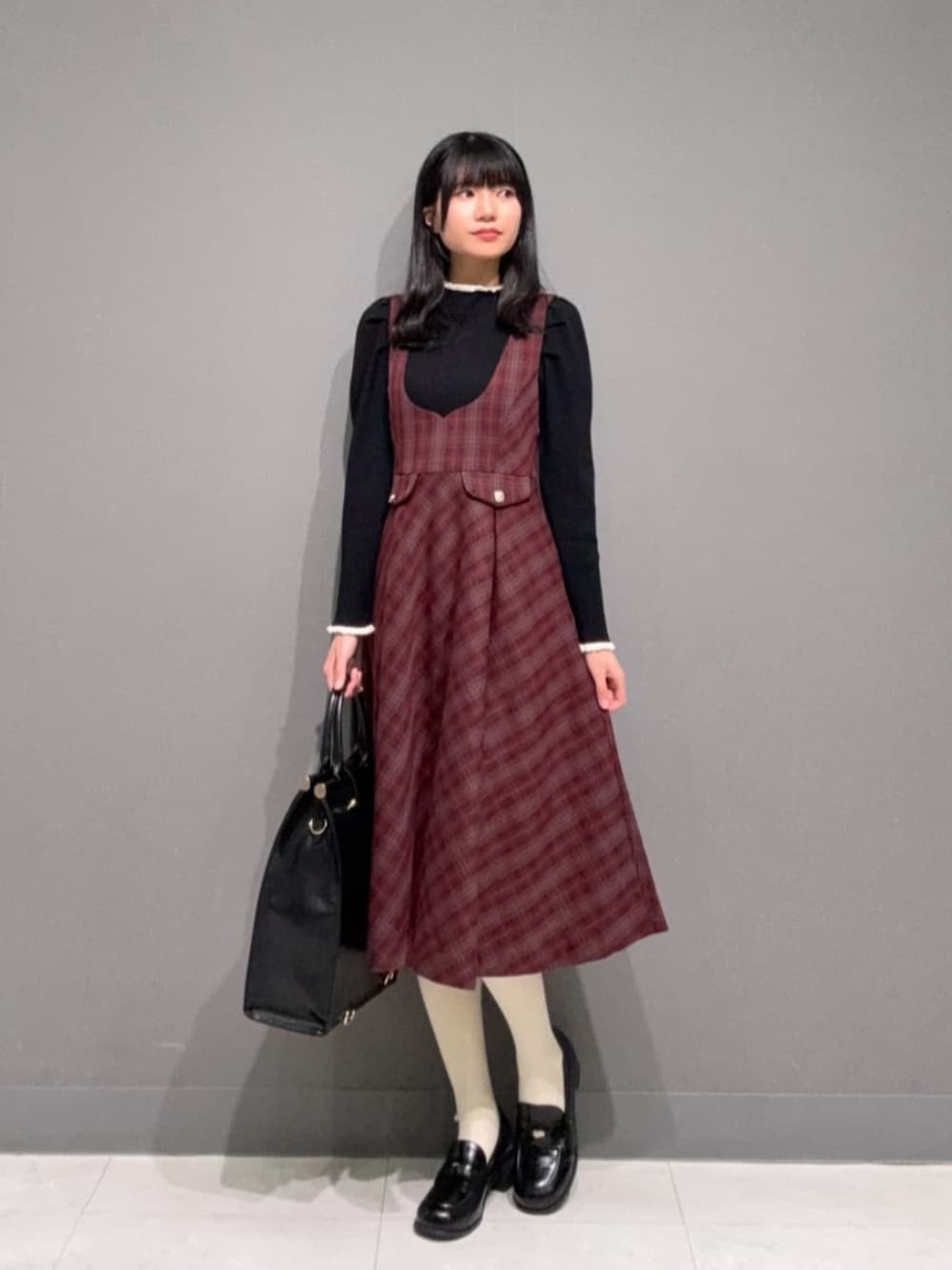 ブラック系のローファー、ブラック系のトートバッグ、ブラック系のニット/セーターを着用したレディースの冬コーディネートの2枚目の写真