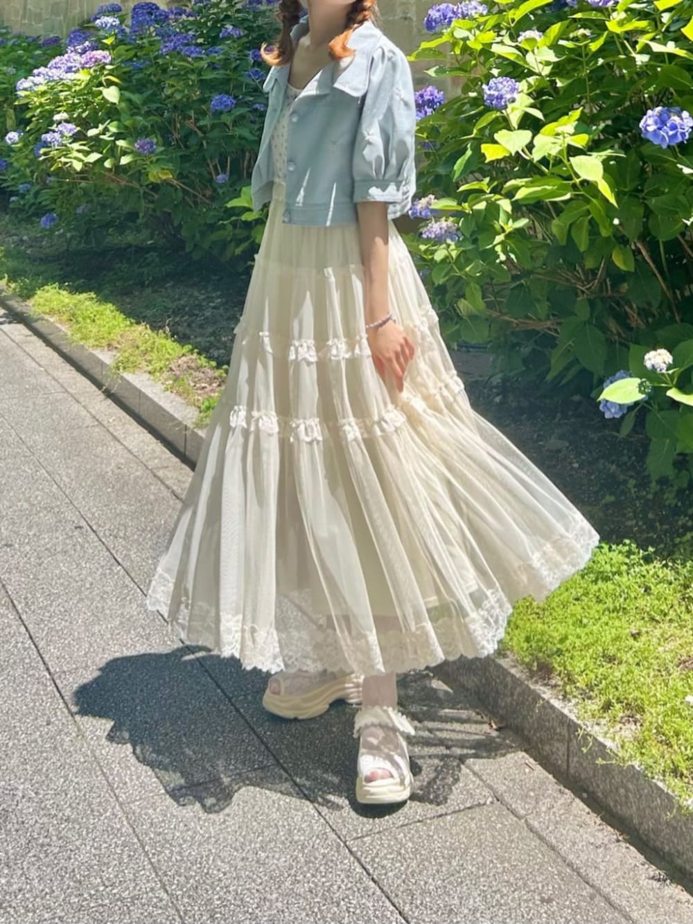 ホワイト系のサンダル、グレー系のその他アウター、ホワイト系のスカートを着用したレディースの夏コーディネートの2枚目の写真