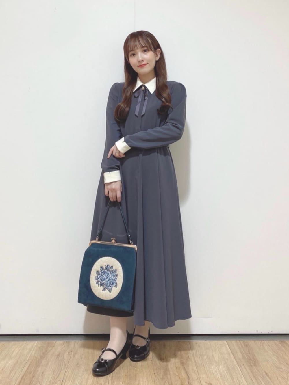 ブラック系のパンプス、グレー系のワンピース、ブルー系のハンドバッグを着用したレディースの秋コーディネートの2枚目の写真