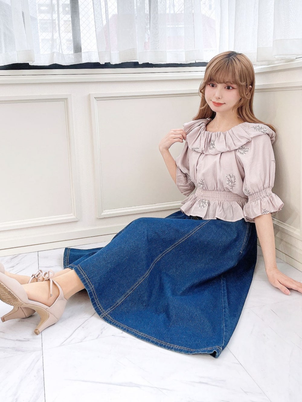 ブルー系のデニムスカート、ピンク系のパンプス、パープル系のシャツ/ブラウスを着用したレディースの春コーディネートの2枚目の写真