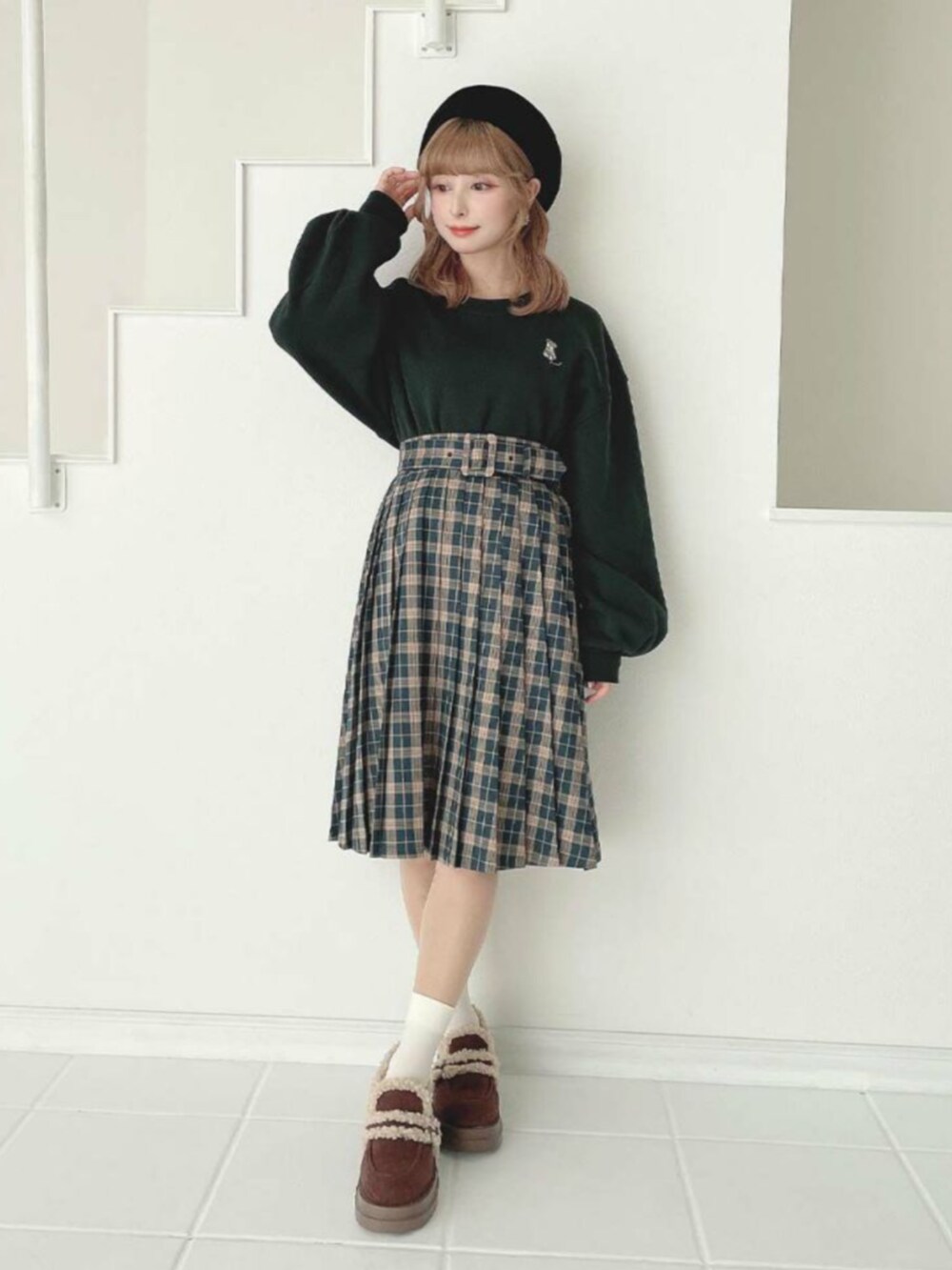 ブラウン系のモカシン/デッキシューズ、グリーン系のスウェット、グリーン系のスカートを着用したレディースの秋コーディネートの2枚目の写真