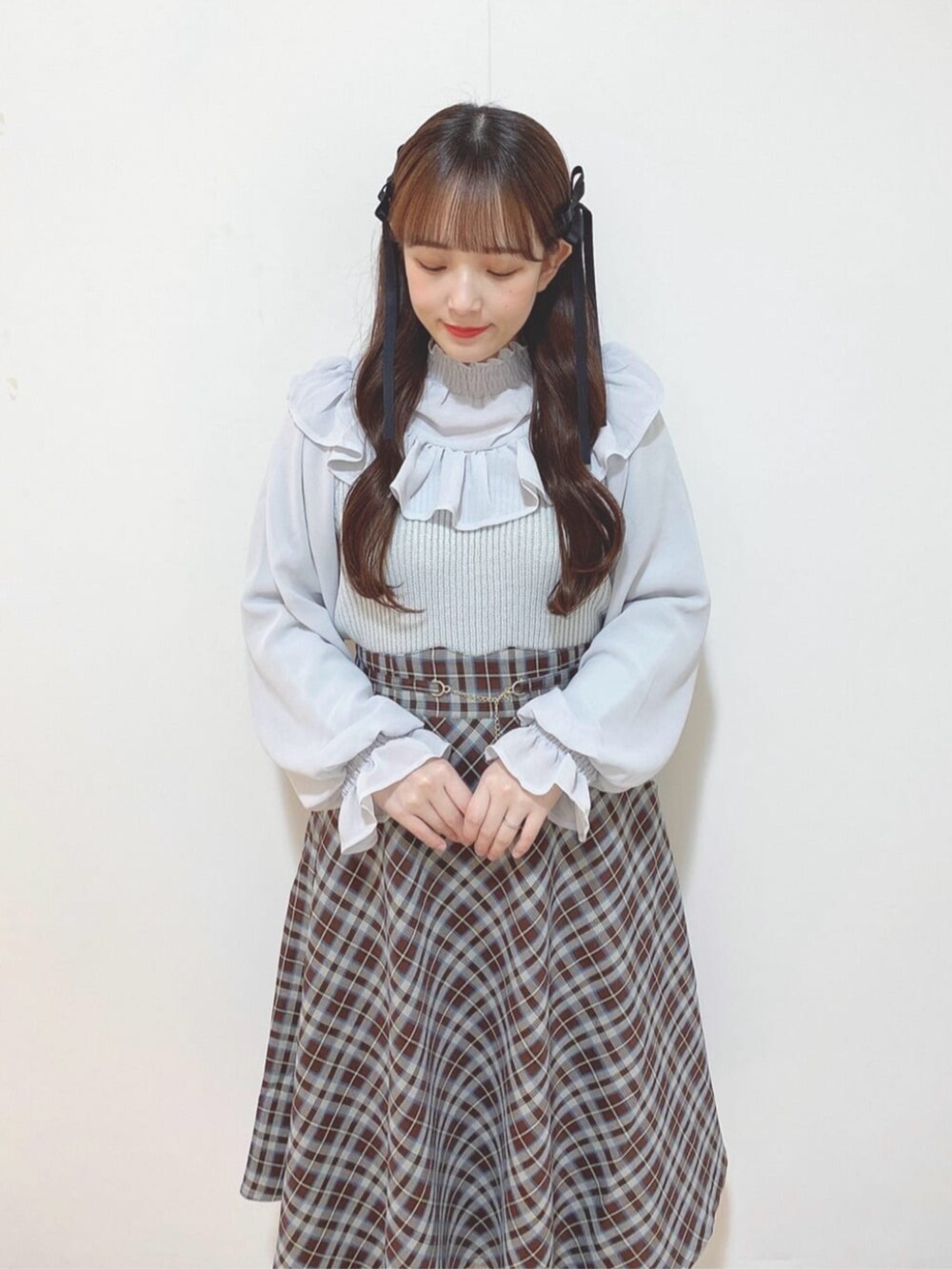 シルバー系のパンプス、ブルー系のスカート、グレー系のニット/セーターを着用したレディースの秋コーディネートの2枚目の写真