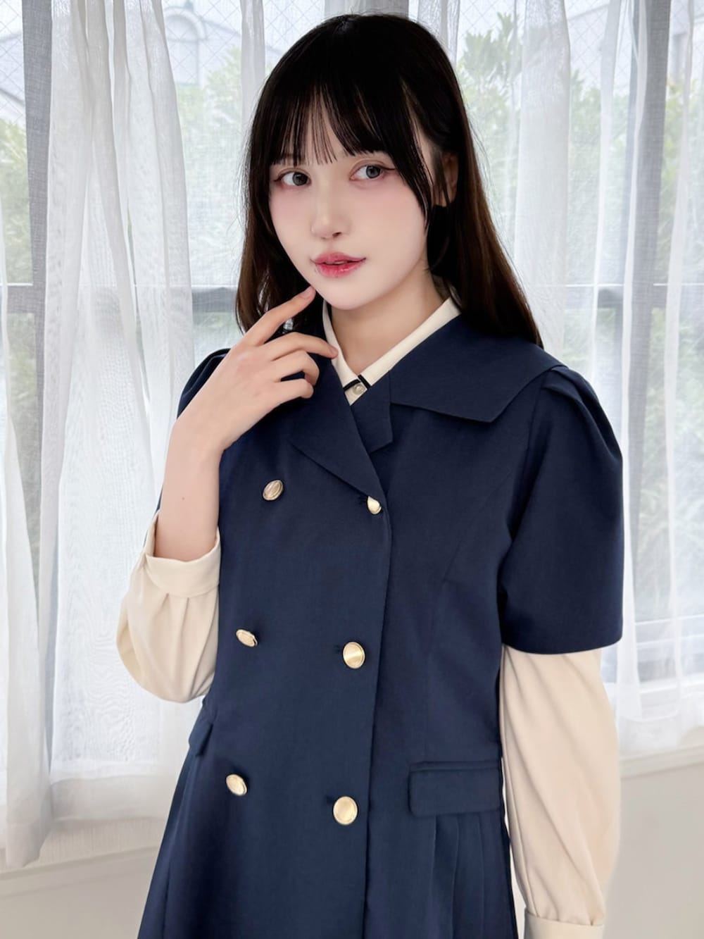 ブラック系のローファー、ホワイト系のハンドバッグ、ブルー系のワンピースを着用したレディースの春コーディネートの3枚目の写真