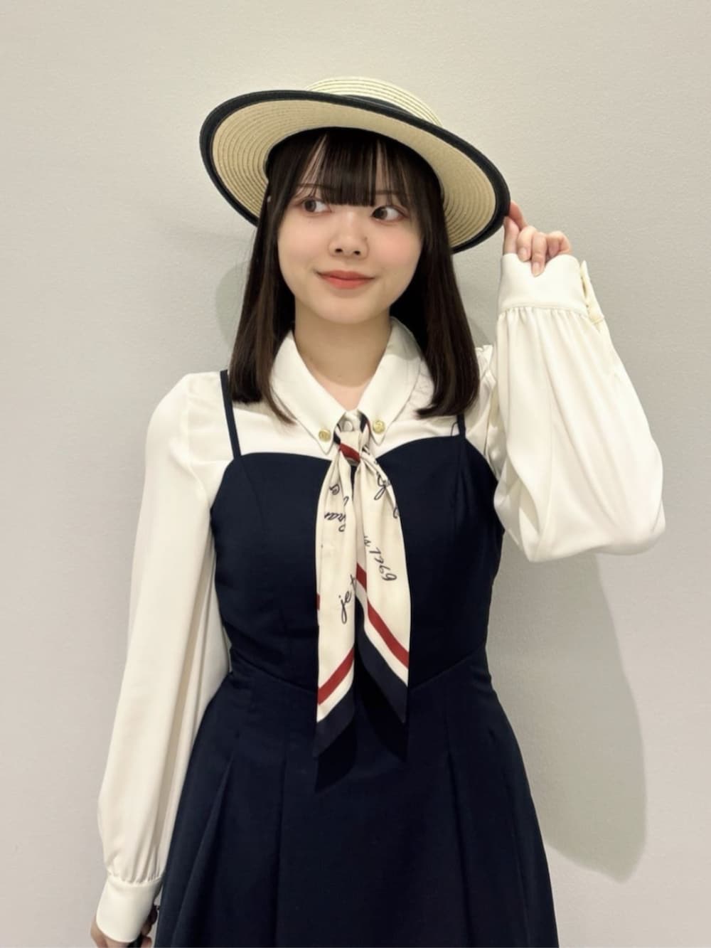 ホワイト系のシャツ/ブラウス、ホワイト系のハンドバッグ、ホワイト系のパンプスを着用したレディースの春コーディネートの2枚目の写真