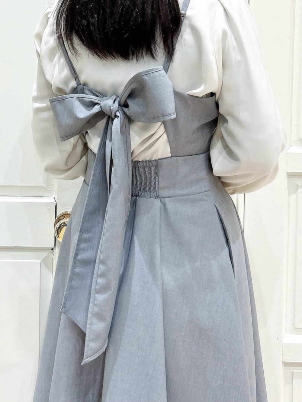 ホワイト系のシャツ/ブラウス、ホワイト系のパンプス、グレー系のワンピースを着用したレディースの春コーディネートの2枚目の写真