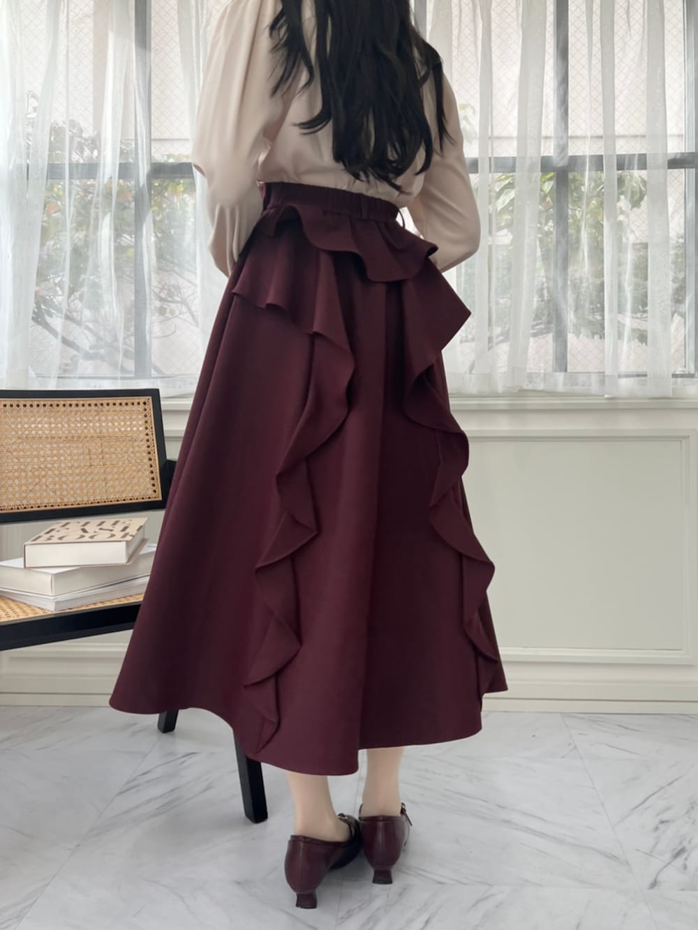 レッド系のパンプス、レッド系のテーラードジャケット、レッド系のスカートを着用したレディースの秋コーディネートの2枚目の写真