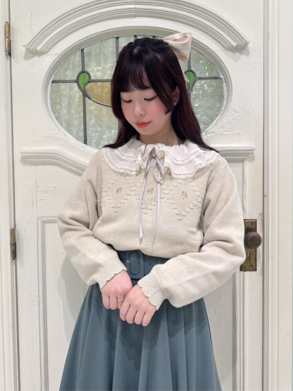 ブラック系のパンプス、グリーン系のスカート、ピンク系のシャツ/ブラウスを着用したレディースの冬コーディネートの3枚目の写真