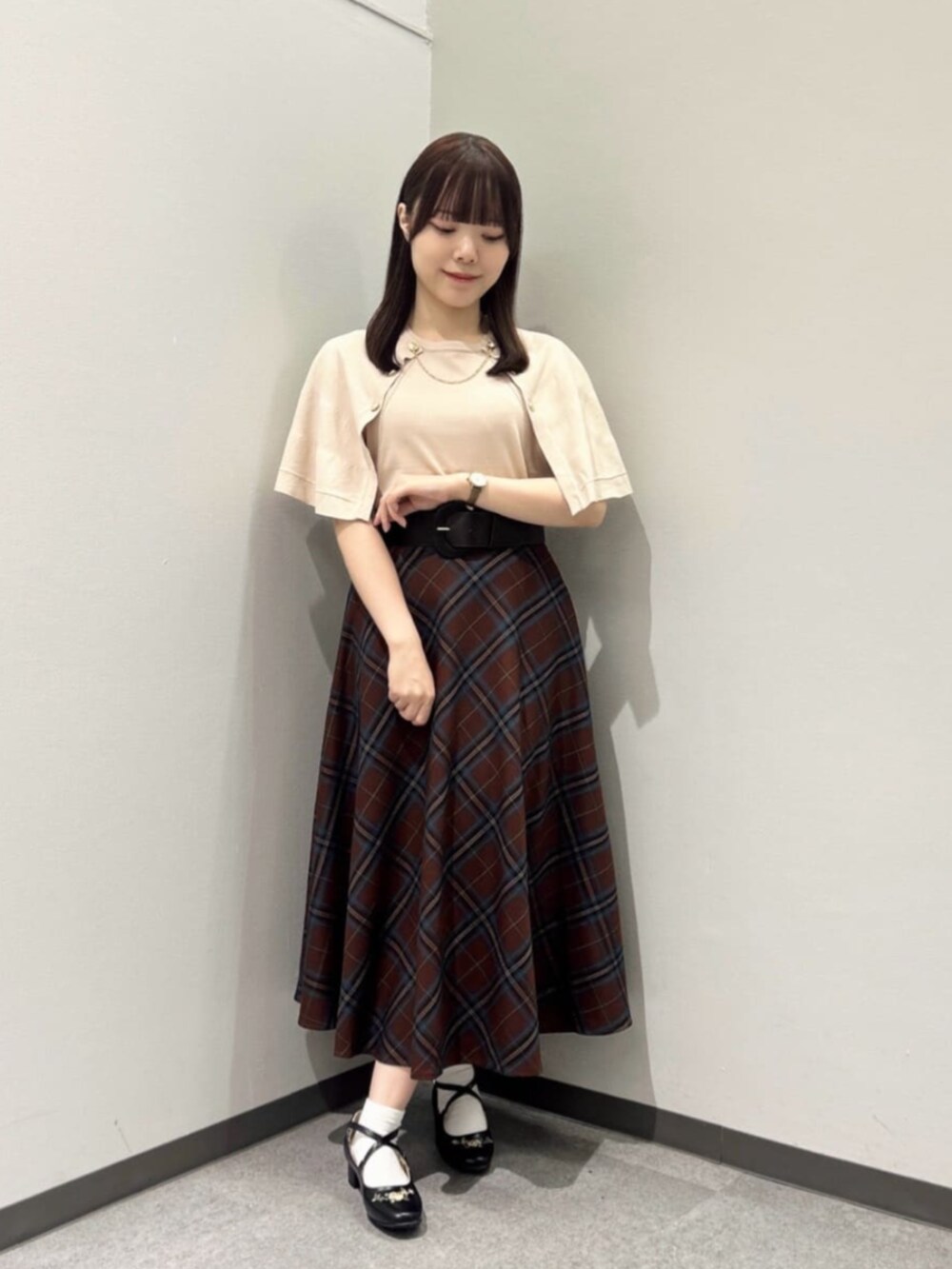 ブラック系のハンドバッグ、ベージュ系のニット/セーター、ブラック系のパンプスを着用したレディースの秋コーディネートの4枚目の写真