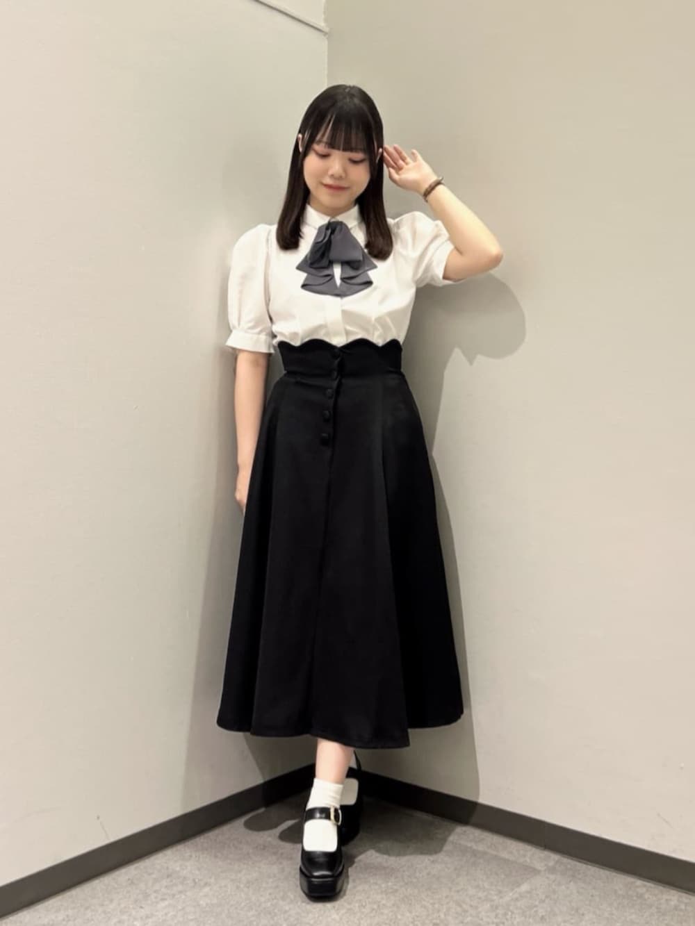 ブラック系のスカート、ホワイト系のシャツ/ブラウス、ブラック系のパンプスを着用したレディースの春コーディネートの2枚目の写真