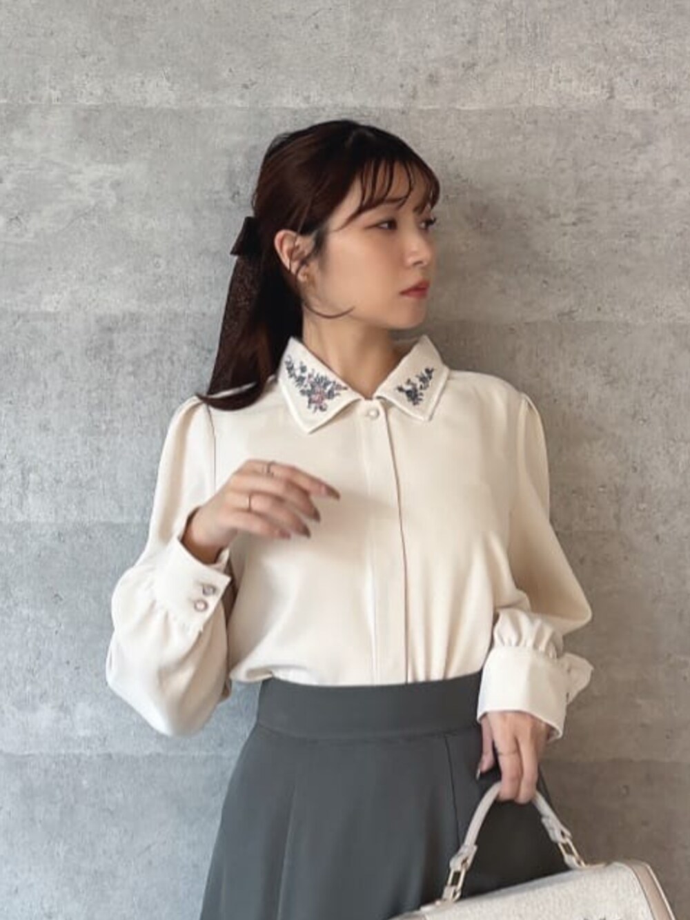 レッド系のパンプス、ホワイト系のハンドバッグ、ホワイト系のシャツ/ブラウスを着用したレディースの冬コーディネートの2枚目の写真