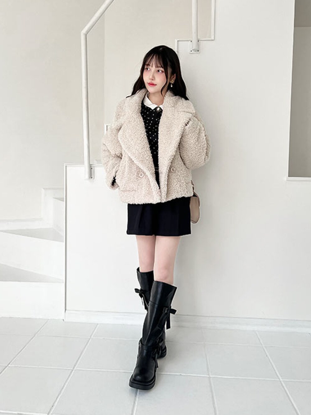 ブラック系のブーツ、ブラック系のその他パンツ、ホワイト系のその他アウターを着用したレディースの冬コーディネートの2枚目の写真