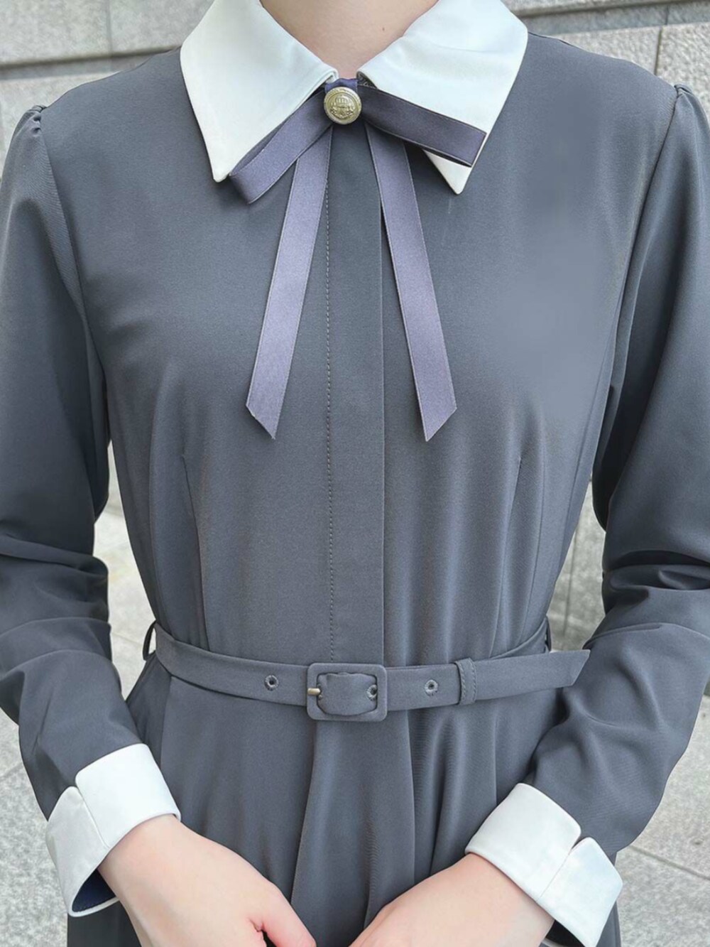 グレー系のワンピース、ブラック系のパンプスを着用したレディースの秋コーディネートの3枚目の写真