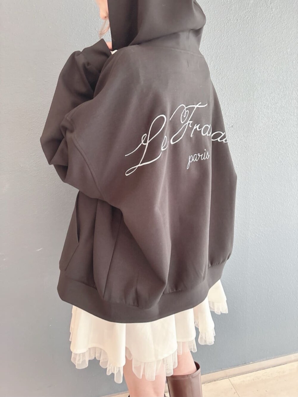 ホワイト系のスカート、ホワイト系のシャツ/ブラウス、ブラック系のパーカーを着用したレディースの冬コーディネートの2枚目の写真