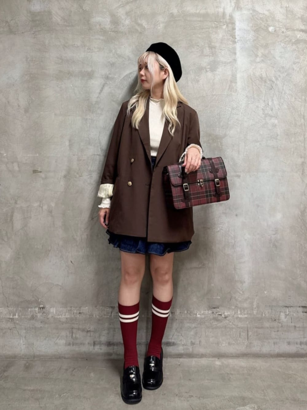 ブラック系のローファー、ブルー系のスカート、ブラウン系のその他アウターを着用したレディースの秋コーディネートの3枚目の写真