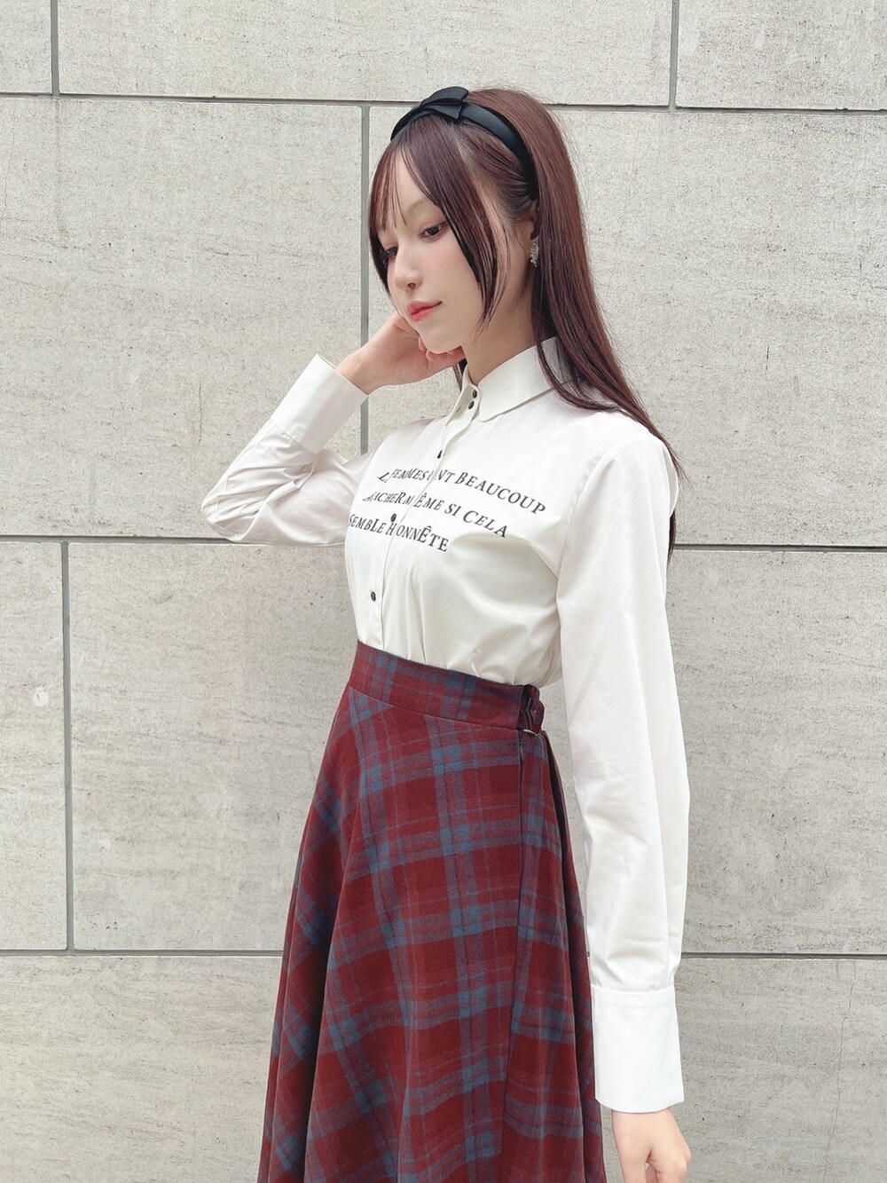 グレー系のパンプス、レッド系のスカート、ホワイト系のシャツ/ブラウスを着用したレディースの秋コーディネートの2枚目の写真