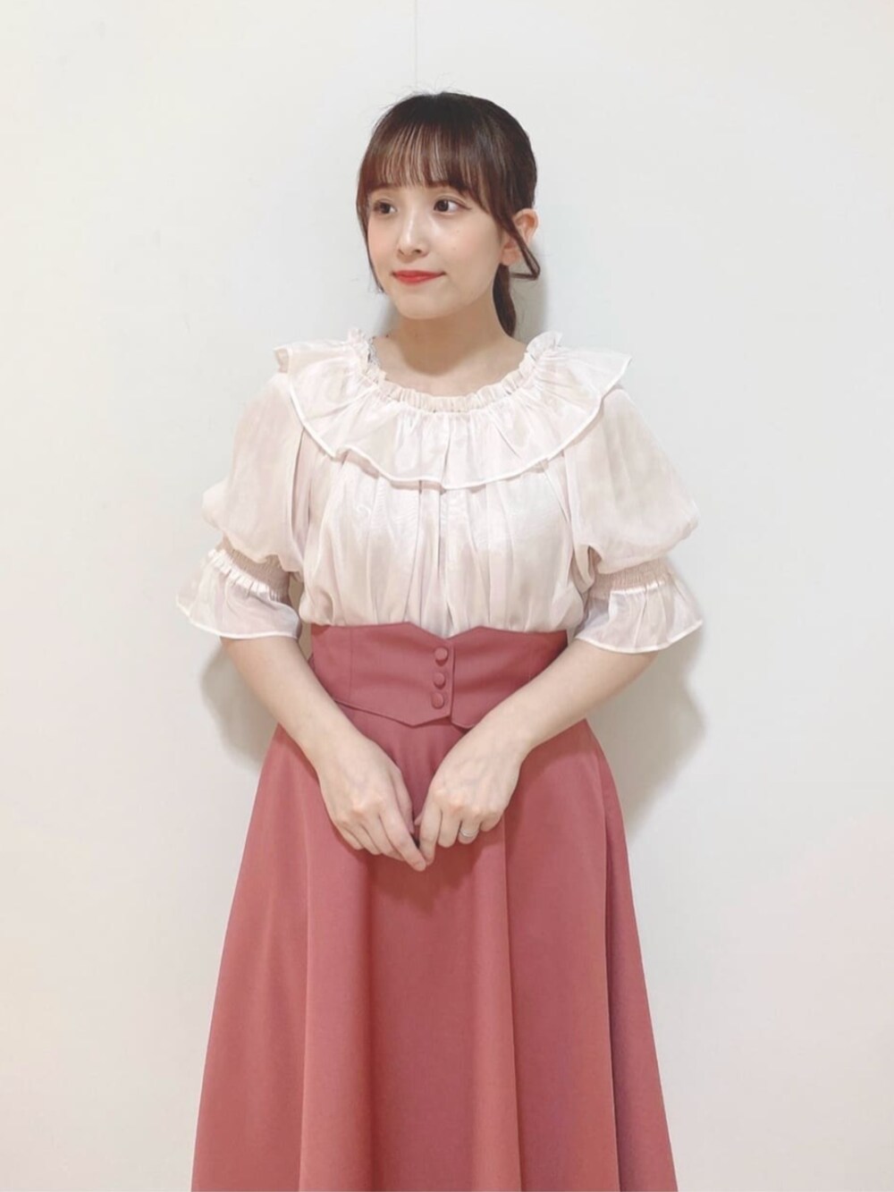 ピンク系のスカート、ブラウン系のパンプス、ピンク系のシャツ/ブラウスを着用したレディースの夏コーディネートの3枚目の写真