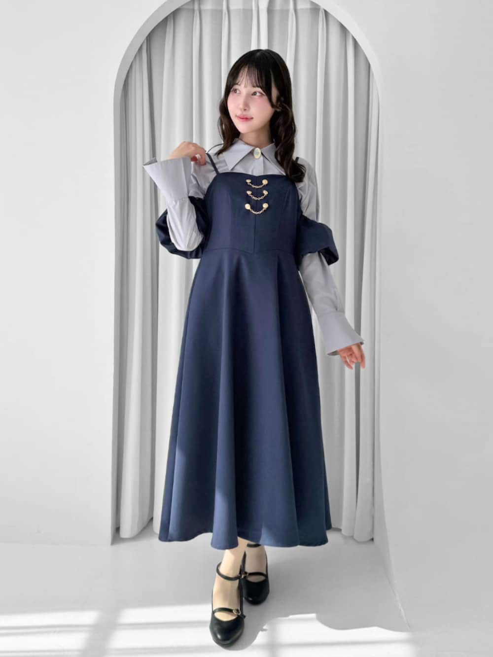 ブラック系のパンプス、ブルー系のワンピースを着用したレディースの秋コーディネートの2枚目の写真