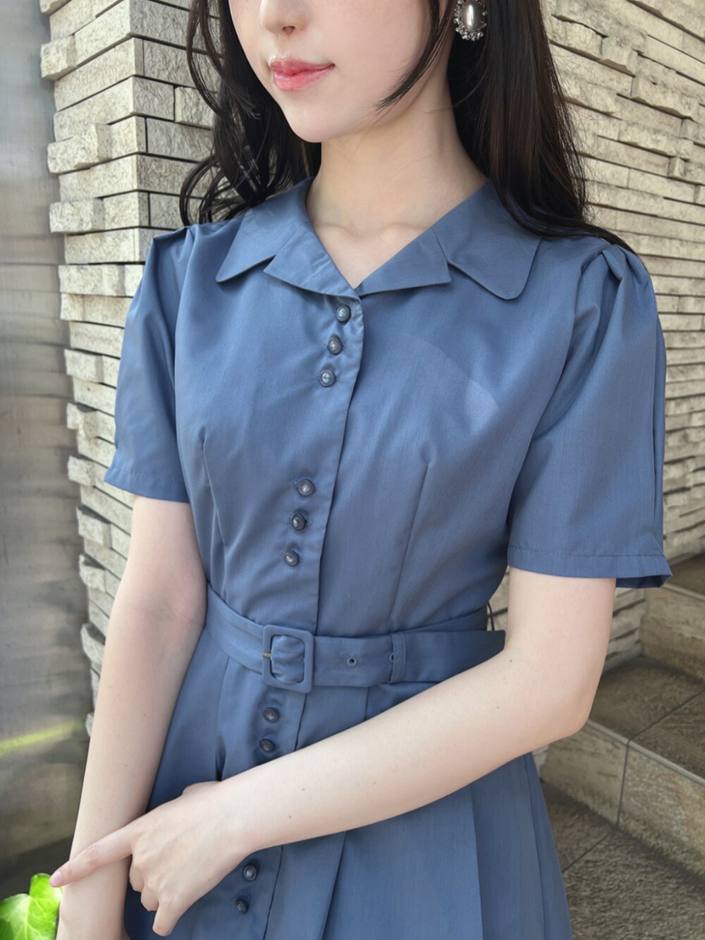 ホワイト系のパンプス、ホワイト系のハンドバッグ、ブルー系のシャツワンピースを着用したレディースの夏コーディネートの2枚目の写真