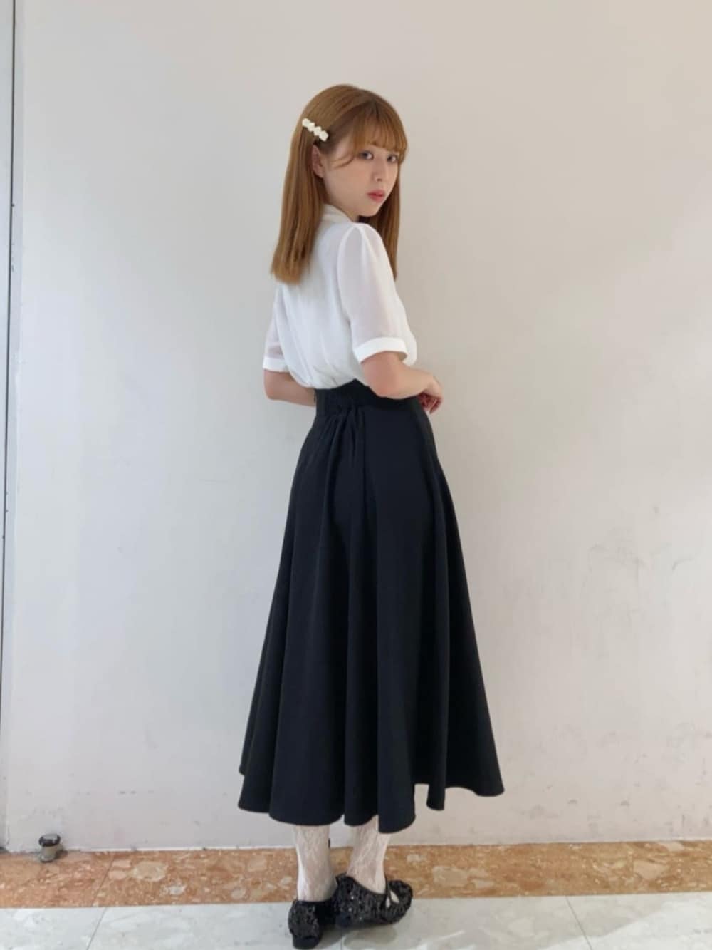 ホワイト系のシャツ/ブラウス、ブラック系のスカートを着用したレディースの春コーディネートの2枚目の写真