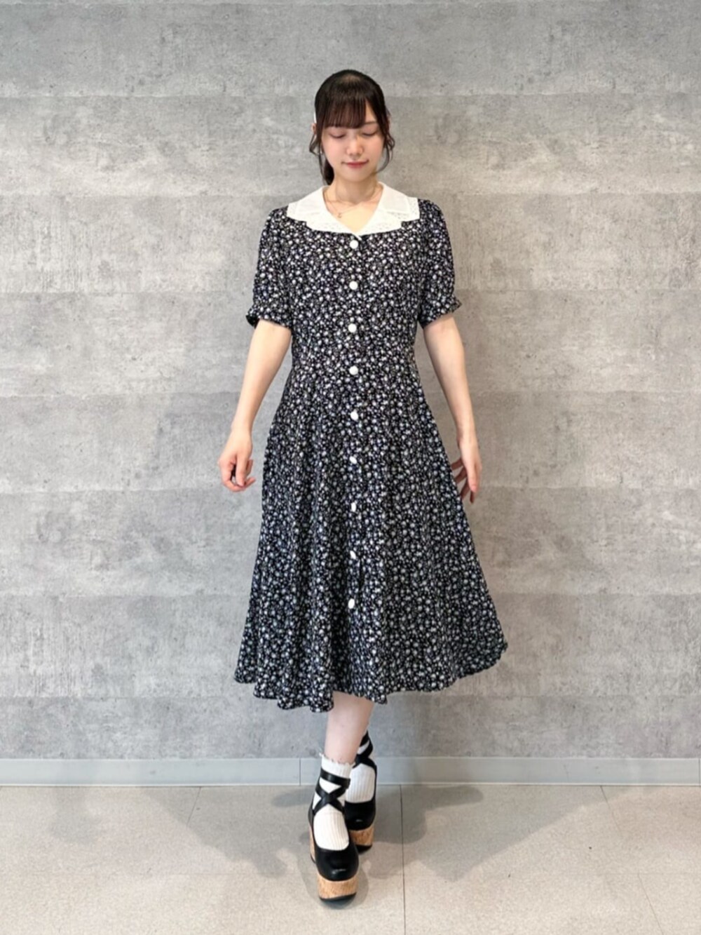 ベージュ系のハンドバッグ、ブラック系のワンピースを着用したレディースの春コーディネートの3枚目の写真