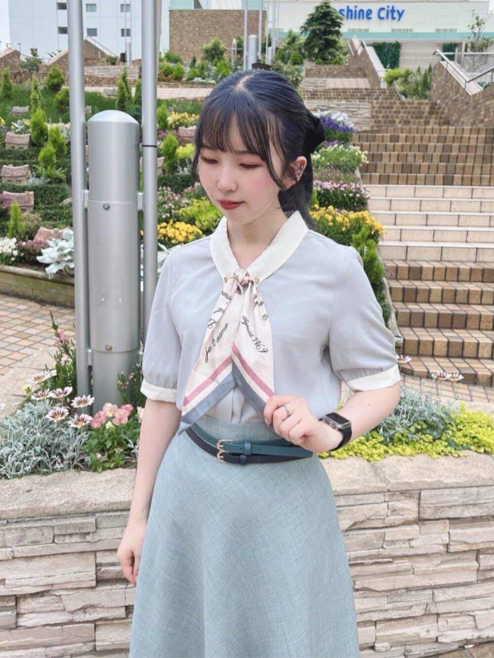 ブルー系のスカート、グリーン系のシャツ/ブラウス、ブラック系のパンプスを着用したレディースの夏コーディネートの2枚目の写真