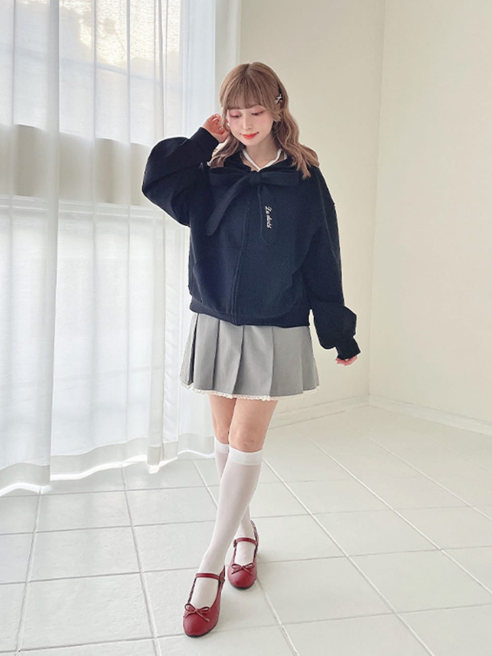 レッド系のバレエシューズ、ブラック系のパーカーを着用したレディースの冬コーディネートの2枚目の写真