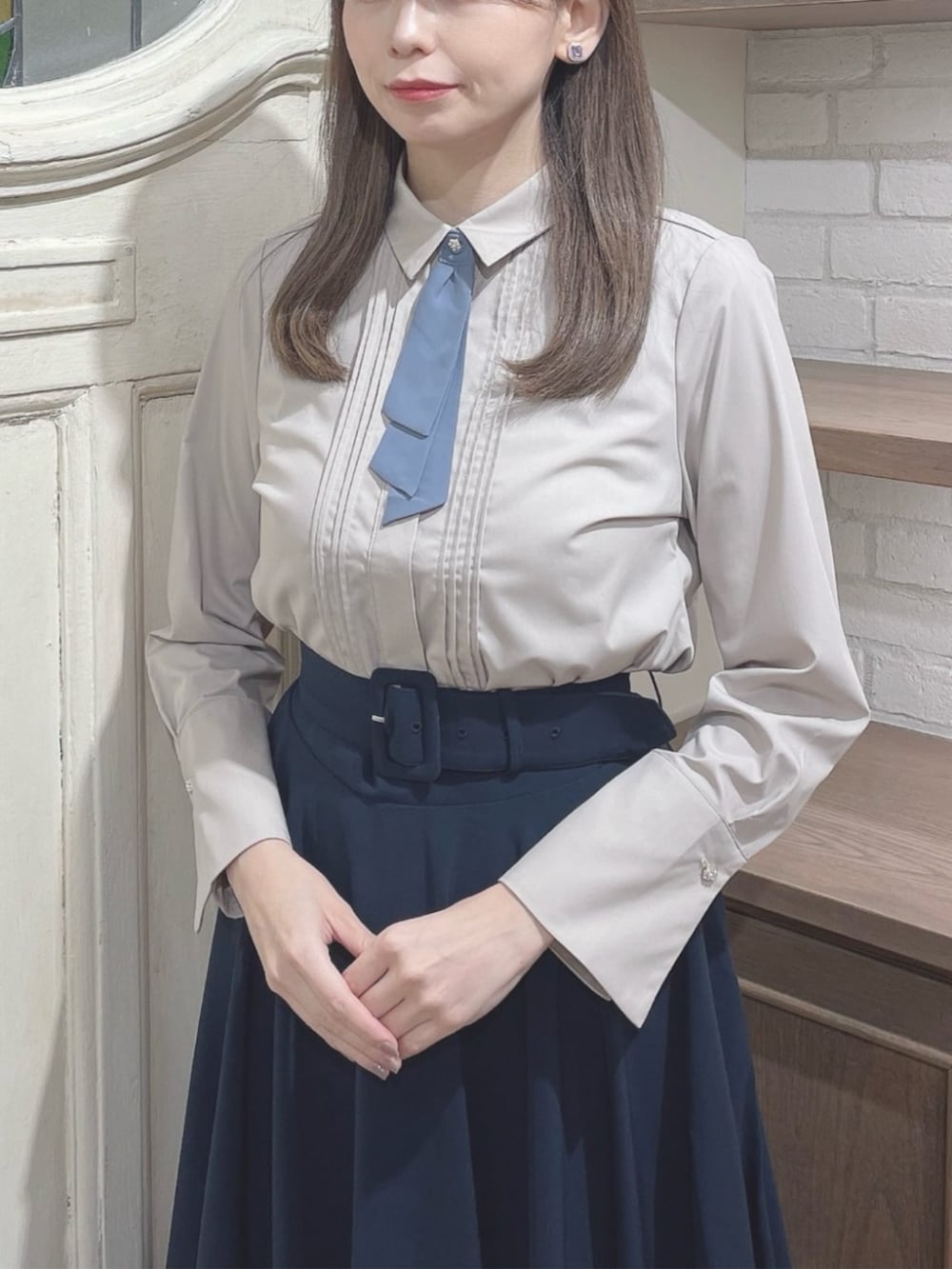 レッド系のパンプス、ベージュ系のシャツ/ブラウス、ブラウン系のハンドバッグを着用したレディースの冬コーディネートの2枚目の写真