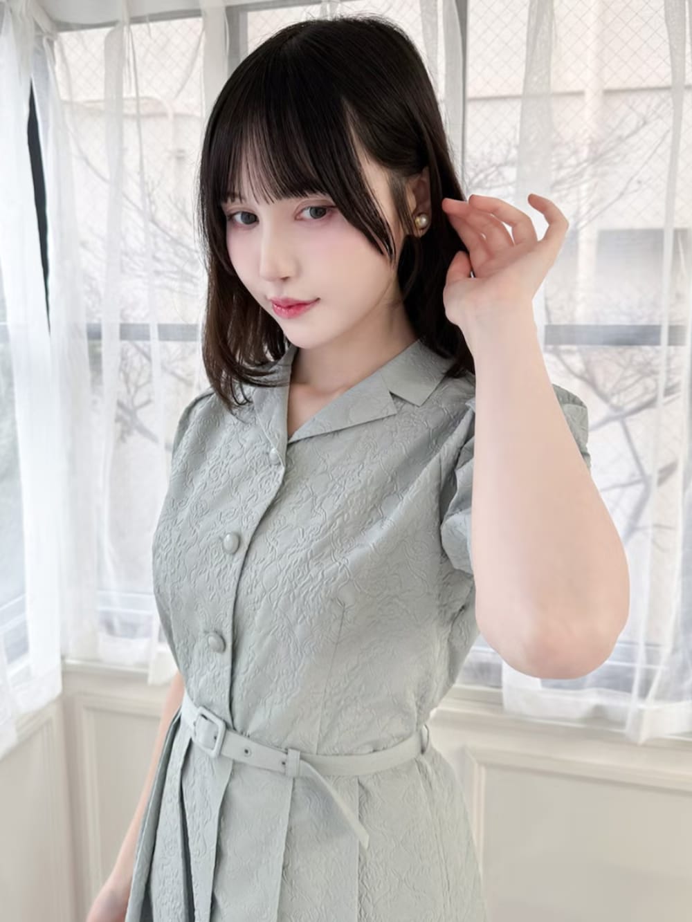 ホワイト系のパンプス、グリーン系のワンピースを着用したレディースの春コーディネートの2枚目の写真