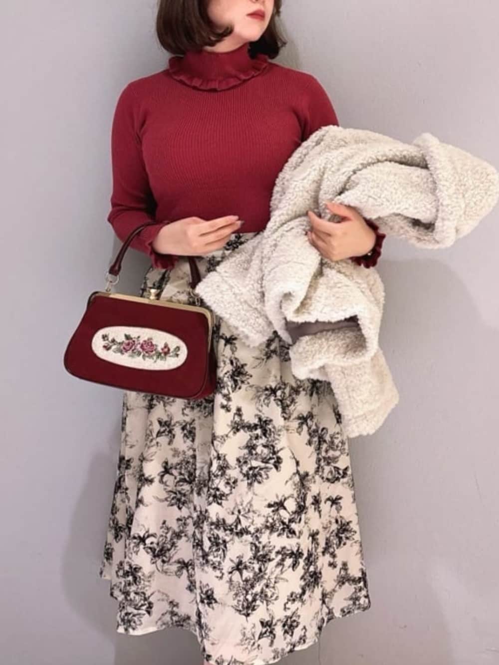 レッド系のハンドバッグ、ブラック系のパンプス、ホワイト系のその他アウターを着用したレディースの秋コーディネートの3枚目の写真